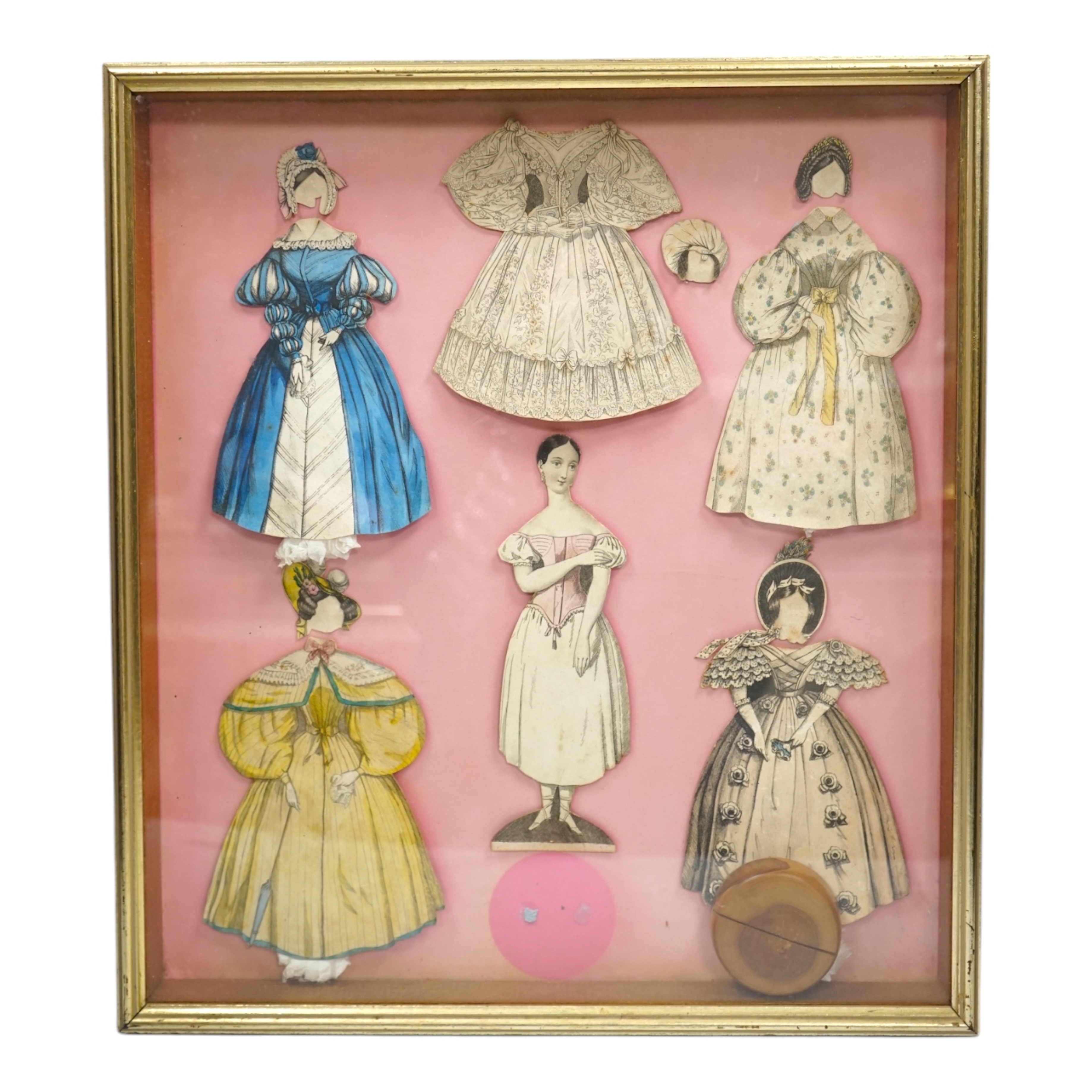 An early 19th century framed Rudolph Ackermann La Poupee-Modele paper doll set, comprising of a double sided doll in lingerie with wooden stand, five double sided gowns and five bonnets, dimensions of the frame; 40cm wid